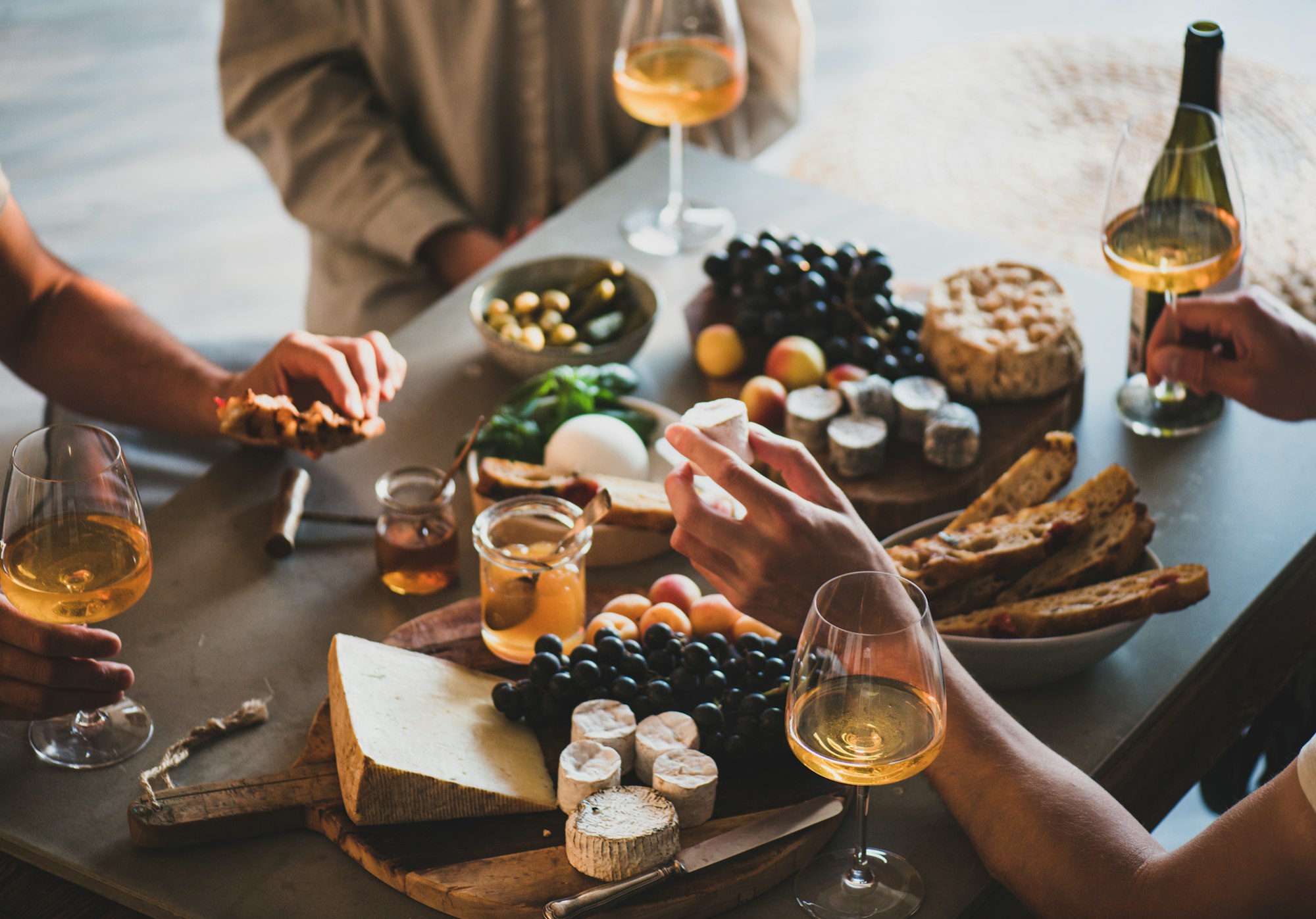 People drinking orange wine eating tasty snacks People drinking orange wine eating tasty snacks