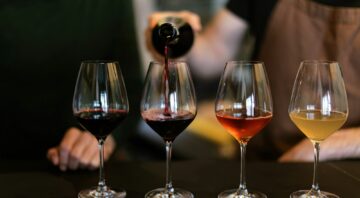 sommelier pouring wine into wine glasses for wine tasting
