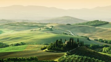 Tuscany landscape at sunrise. Tuscan farm house, vineyard, hills.